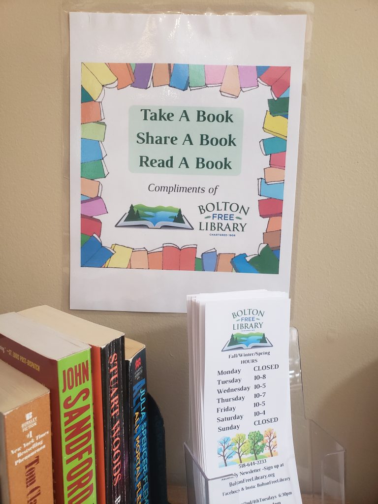 The Take A Book Share A Book sign for the bookshelf at the Bolton Health Center.